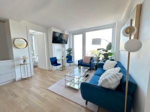 a living room with a blue couch and blue chairs at Modern One Bedroom - Large Private Terrace - Luxury Building - Williamsburg in Brooklyn