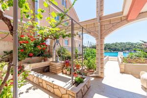 an outdoor patio with potted plants and a building at Apartments by the sea Prizba, Korcula - 175 in Prizba