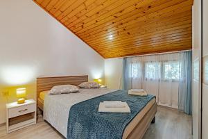 a bedroom with a large bed with a wooden ceiling at Apartments by the sea Prizba, Korcula - 175 in Prizba +41 photos
