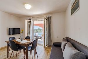 a living room with a couch and a table and chairs at Apartments by the sea Prizba, Korcula - 175 in Prizba