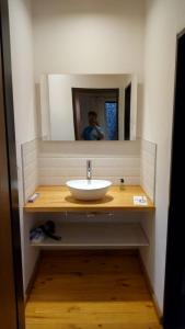 a bathroom sink with a mirror and a man taking a picture at Casa Selva in Costa del Este