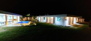 a house with a swimming pool at night at Pousada Lírios do Campo in Paraty