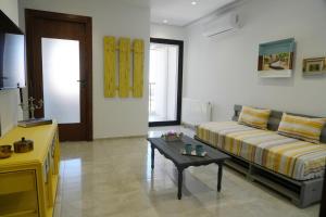 uma sala de estar com um sofá e uma mesa de centro em Le soleil jaune em Sfax