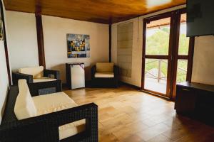 a living room with chairs and a refrigerator at Ranchos de Chalia Panama in Portobelo