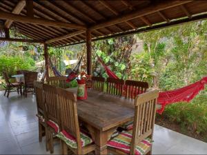 a wooden table and chairs on a porch with a hammock at Quinta da Pedra do Elefante in Araras Petropolis