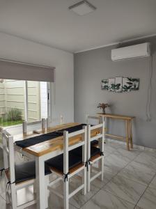 a dining room with a wooden table and chairs at casa quinta caballito blanco in Chascomús
