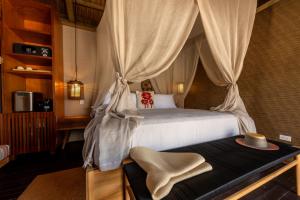 a bedroom with a bed with a canopy at ACASI Rustic Beach in Baru