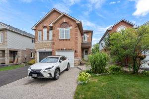 a white car parked in front of a house at Ninos place in Hamilton