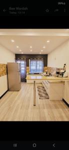 a large kitchen with a refrigerator and a counter at Avenue soleil sur mer flic en flac in Flic-en-Flac