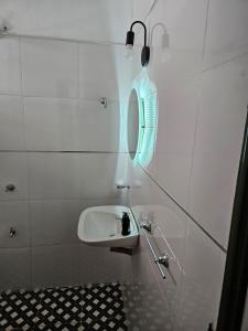 une salle de bain blanche avec un lavabo et un miroir dans l'établissement departamentos temporarios corrientes, à Corrientes 23 autres photos