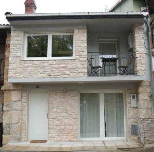 a stone house with two chairs on a balcony at Casa rural Villa Cardil en la entrada del parque Cabarceno in Obregon