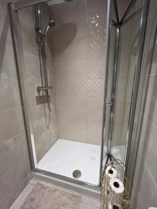 a shower with a glass door and two rolls of toilet paper at 2025 Award Winner Liverpool Cherry House - 4 Bedrooms in Liverpool +102 photos