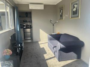 a living room with a blue couch and a television at The Belfry in Taupo
