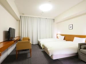 金泽Dormy Inn Kanazawa Natural Hot Spring的一间有两张床和一台电视的酒店房间
