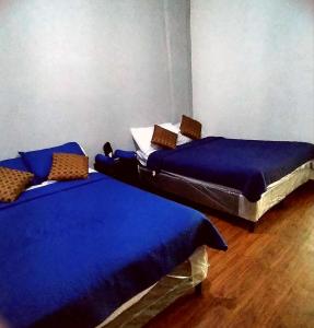 two twin beds in a room with blue sheets at costa azul apartment el zonte in La Libertad
