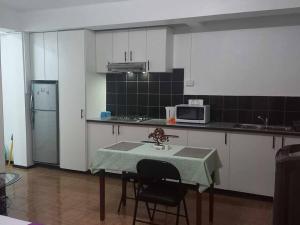 a kitchen with a table with chairs and a microwave at Studio Apartment in Namaka Nadi in Nadi