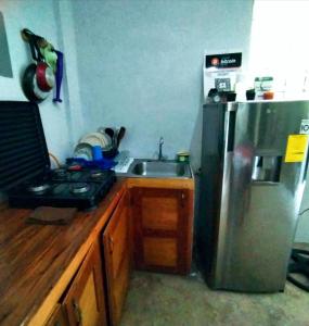 a kitchen with a stainless steel refrigerator and a sink at costa azul apartment el zonte in La Libertad