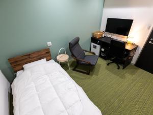 a bedroom with a bed and a desk and a computer at Kiso Mikawaya in Kiso