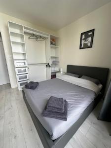 Un dormitorio con una cama con toallas. en Appart ensoleillé à Boulogne Billancourt, en Boulogne-Billancourt