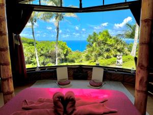 a room with a bed with a view of the ocean at Maui Eco Retreat in Huelo