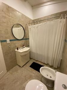 a bathroom with a toilet and a sink and a mirror at Casa en Costa Esmeralda in Costa Esmeralda