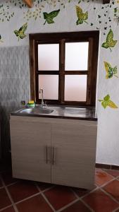 a kitchen with a sink and a window at La Villa in Zapatoca