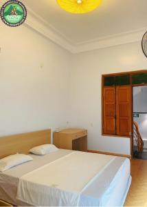 a bedroom with a large white bed in a room at Andy Hoang Riverside Hostel Bar Restaurant Music Beer & More in Ha Giang