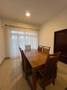 a dining room with a wooden table and chairs at TranquilZ in Kandy