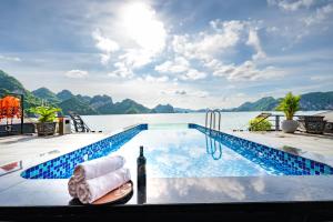 a swimming pool with a bottle of wine next to the water at Venus Cruises Halong Bay in Ha Long