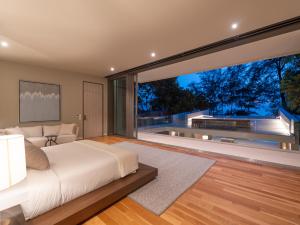 a bedroom with a bed and a large window at Veyla Natai Residences - Luxury Pool Villa in Khok Kloi