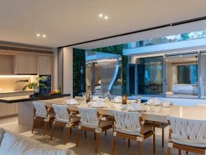 a dining room with a table and chairs and a kitchen at Veyla Natai Residences - Luxury Pool Villa in Khok Kloi