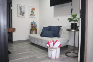 a living room with a white couch and a basket at Las 3 Carabelas BCS in El Sargento