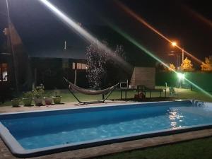 a swimming pool with a hammock and a water sprinkler at Loft en casa particular in General Acha