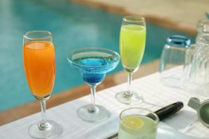 four glasses of different colored drinks on a table at Kutani Bagh Sariska in Tehla