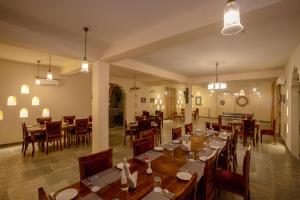 a dining room with wooden tables and chairs at Kutani Bagh Sariska in Tehla