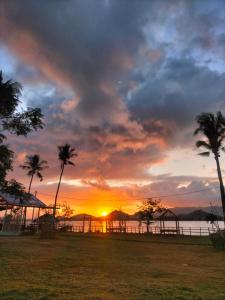 un tramonto con palme di fronte all'acqua di Beach Camp Bed & Breakfast a Gili Sudak Altre 28 foto