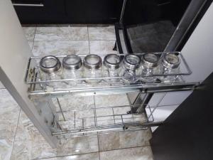 a row of silver canisters on a shelf in a refrigerator at Hermoso, Apartamento zona Este in Barquisimeto +41 photos