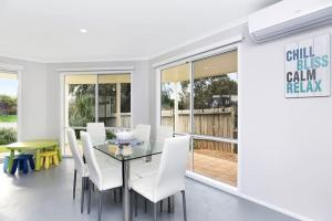 a dining room with a glass table and white chairs at 91 On the Rocks 91 Port Elliot Rd Hayborough Chiton - No Linen Included in Hayborough