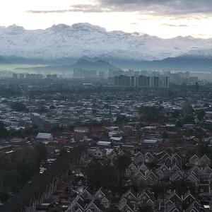 a view of a city with snow capped mountains in the background at 2108 Depto a 15 minutos del Aeropuerto frente mall in Santiago