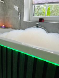 a bath tub filled with lots of foam next to a window at Ferienhaus Doina in Gehlberg