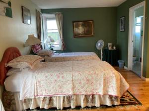 a bedroom with a bed and a window and a fan at Tudor House Bed and Breakfast in Bottrel