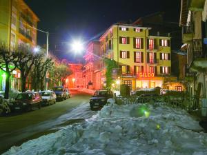 a snow covered city street at night with buildings at Residenza Gildo in Frabosa Soprana