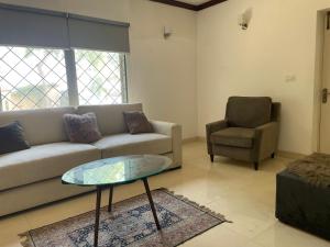 a living room with a couch and a chair at Townhouse Room in a Quiet Neighborhood in Rāmkot