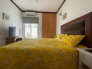 a bedroom with a yellow bed with a yellow comforter at Townhouse Room in a Quiet Neighborhood in Rāmkot