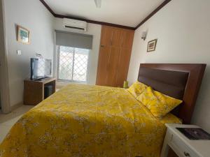 a bedroom with a yellow bed with a yellow blanket at Townhouse Room in a Quiet Neighborhood in Rāmkot