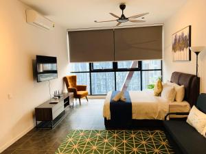 Un dormitorio con una cama, un televisor y un sofá. en Scarletz Suites KLCC by GC Luxury Suites, en Kuala Lumpur