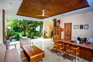a living room with a wooden table and chairs at Arkadewi 1 BR Dleuxe Pool View ZN172 in Ubud