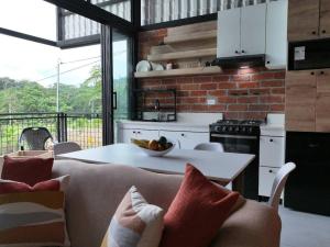 a kitchen and living room with a couch and a table at Casa Sol Del Oriente Joaquín in Tena