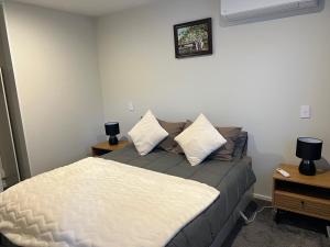 una camera da letto con un letto e due comodini di Christchurch Airport Stop a Christchurch