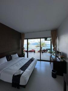 a bedroom with a large bed with a view of the ocean at Tiara Bunga Hotel & Villa in Balige